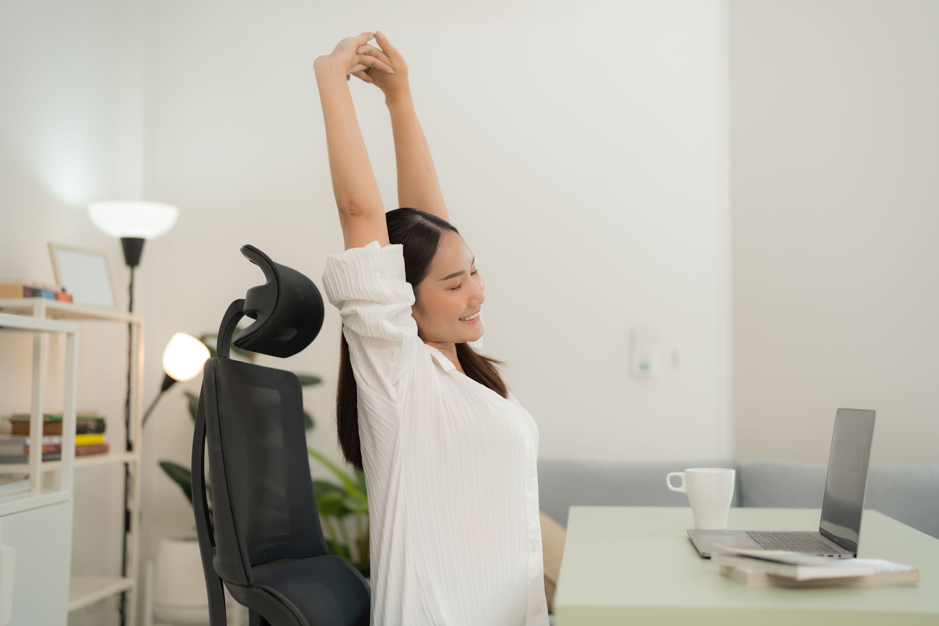 Young woman stretching while working from home Young woman stretching while working from home